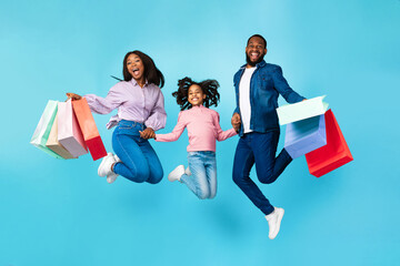 Wall Mural - Excited cheerful black people jumping and holding shopping bags