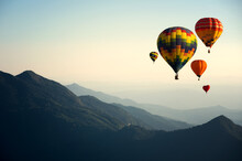 Hot Air Balloons Flying In Mountains Against Clear Sky