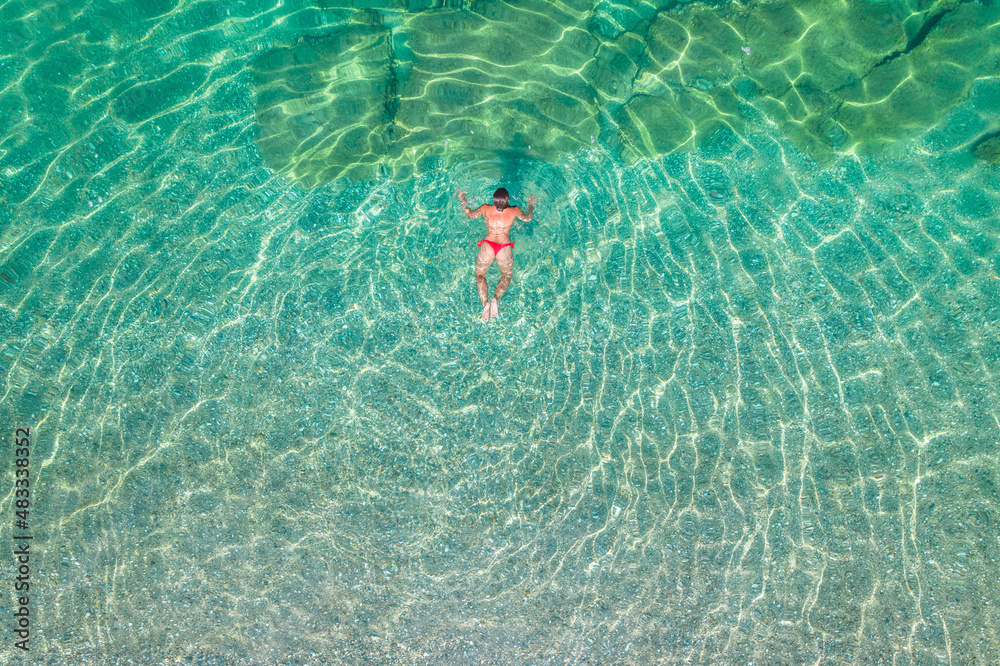 Top, aerial view. Young beautiful woman in a red bikini panties ...