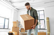 © Syda Productions - moving, people and real estate concept - happy smiling man holding boxes with stuff at new home