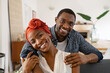 © Rido - Cheerful black couple embracing at home