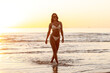 © Syda Productions - people, summer and leisure concept - happy smiling young woman in bikini swimsuit on beach over sunset
