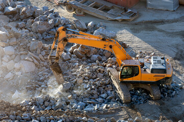 A hydraulic breaker is mounted on the excavator. It is powered by an auxiliary hydraulic system from the excavator, which is fitted with a foot-operated valve for this purpose.