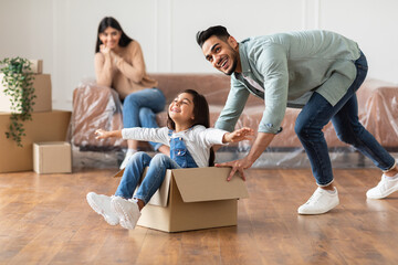 Canvas Print - Happy arab father riding daughter in cardboard box