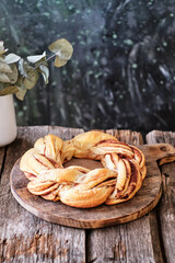 Sticker - Cinnamon bun wreath. Brioche. Side view, wooden background, coffee, cocoa powder, yeast buns.