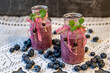 Two bottles decorated with ribbons of delicious healthy yoghurt, smoothie, blueberry smoothie