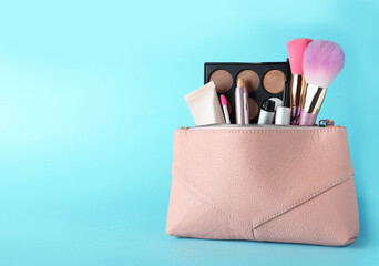 Canvas Print - Cosmetic bag with makeup products and accessories on light blue background. Space for text