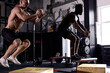 © Roman - Young strong fit sweaty muscular men with big muscles doing box jump workout in modern cross fit gym, training together, real people exercise. Handsome two shirtless guys are engaged in sport