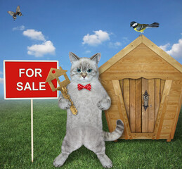 Wall Mural - An ashen cat in a red bow tie holds a house key near a log cabin with a sign House for sale.