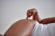 © Roman - Tempting young sexy fat female in white bodysuit is lying, touching smooth silky skin on hip after cosmetic procedure, anti-cellulite therapy over white studio background. close-up legs, plus size