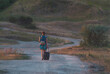 © drakuliren - girl with a backpack walks along the road in the sunset