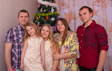 Wall Mural - Happy family at the Christmas tree on New Year's holidays.