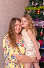 Poster - Joyful mom and daughter near the Christmas tree on New Year's holidays.