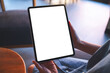 © Farknot Architect - Mockup image of a woman holding digital tablet with blank white desktop screen in cafe