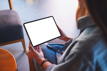 Mockup image of a woman holding digital tablet with blank white desktop screen in cafe
