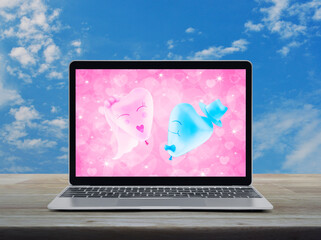 Bride and Groom love heart balloon over pink love heart screen on modern laptop computer monitor on wooden table over blue sky with white clouds, Business internet dating online, Valentines day concep