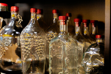 Shaped glass bottles on the shelf. Close-up.