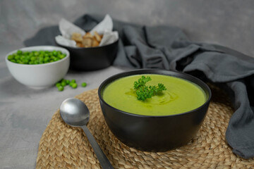 Summer cream soup with green fresh pea shoots.