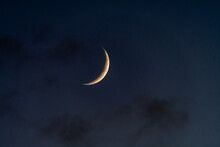 A Waning Crescent Moon In A Dark Sky