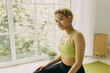 © shurkin_son - Crop shot of young charming woman of mixed race posing against white huge panoramic window, looking at camera with calm, enigmatic, mysterious eyes, sitting on floor at her quiet house