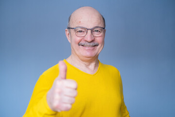 Poster - Senior man thumbs up isolated over blue background