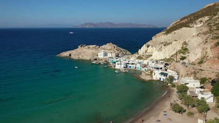 Wall Mural - Aerial drone video of beautiful fishermen seaside village and small sandy beach of Firopotamos with colourful boat houses called 