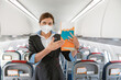 © Kostiantyn - Woman stewardess in medical mask holding instruction booklet