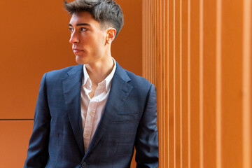 Portrait of a young business man on an orange background. Young entrepreneur concept.