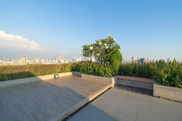 Sky garden on private rooftop of condominium or hotel, high rise architecture building with tree, grass field, and blue sky.