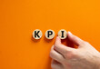 KPI, key performance indicator symbol. Concept word KPI, key performance indicator on wooden circles on beautiful orange background, copy space. Business, KPI, key performance indicator concept.