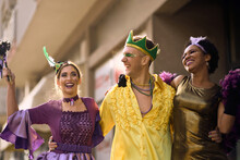Cheerful Group Of Friends In Carnival Costumes Have Fun On Street Parade During Mardi Gras Festival.