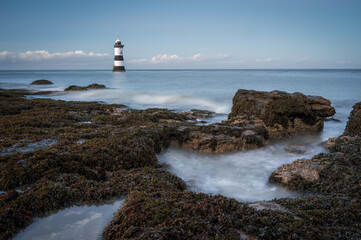 Poster - The Penmon Point Lighthouse surrounded by the sea with long exposure in Anglesey, Wales