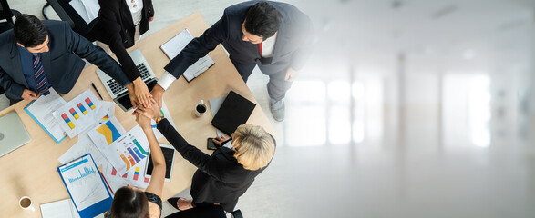 Happy business people celebrate teamwork success in widen view together with joy at office table shot from top view . Young businessman and businesswoman workers express cheerful victory .