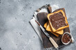 Toast with chocolate Hazelnut spread on wooden board. Gray background. Top view. Copy space
