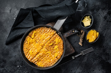 Wall Mural - Cooking of French crepe Suzette with orange sauce in a skillet. Black background. Top view