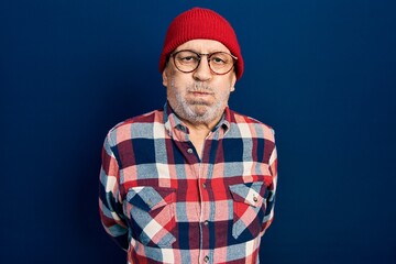 Canvas Print - Handsome mature man wearing hipster look with wool cap puffing cheeks with funny face. mouth inflated with air, crazy expression.