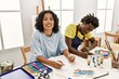 © Krakenimages.com - African american artist couple smiling happy painting sitting on the table at art studio.