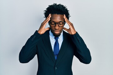 Poster - Young african american man wearing business suit suffering from headache desperate and stressed because pain and migraine. hands on head.