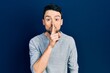 © Krakenimages.com - Young hispanic man wearing casual clothes asking to be quiet with finger on lips. silence and secret concept.