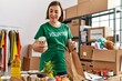 © Krakenimages.com - Middle age hispanic woman preparing bag with groceries at donations stand