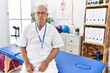 © Krakenimages.com - Senior physiotherapy man working at pain recovery clinic relaxed with serious expression on face. simple and natural looking at the camera.