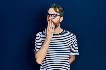 Wall Mural - Caucasian man with beard wearing striped t shirt and glasses bored yawning tired covering mouth with hand. restless and sleepiness.