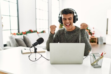 Poster - Handsome hispanic man recording podcast screaming proud, celebrating victory and success very excited with raised arms