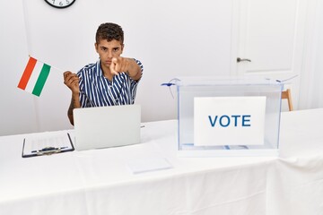 Sticker - Young handsome hispanic man at political campaign election holding hungary flag pointing with finger to the camera and to you, confident gesture looking serious