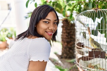 Hispanic brunette woman looking at bird at the terrace