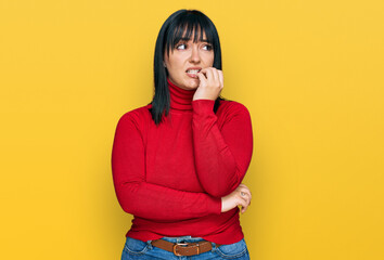 Sticker - Young hispanic woman wearing casual clothes looking stressed and nervous with hands on mouth biting nails. anxiety problem.