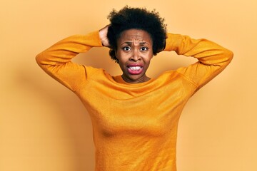 Poster - Young african american woman wearing casual clothes crazy and scared with hands on head, afraid and surprised of shock with open mouth