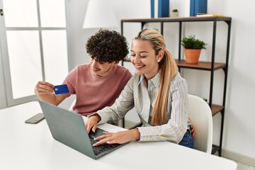 Poster - Young couple buying using laptop and credit card at home.