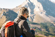 © ADDICTIVE STOCK - Senior traveling woman browsing on mobile phone on mountains