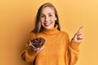 © Krakenimages.com - Young blonde woman holding bowl of star anise smiling happy pointing with hand and finger to the side